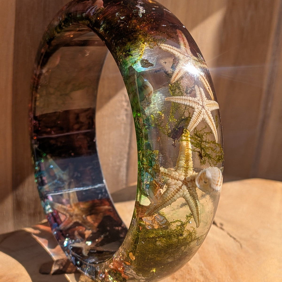 Handmade resin bangle with real ocean inclusions 70mm inner diameter warm amber green tones on driftwood – EL-Creations