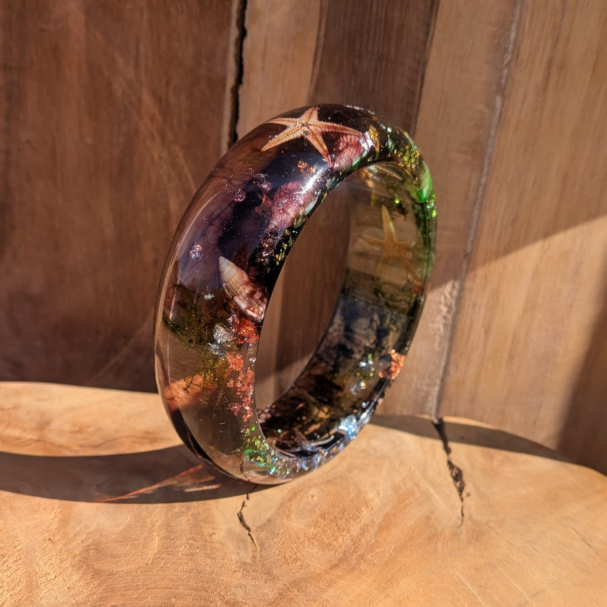 Clear resin bangle with dried starfish and sea moss close-up showing gold copper silver flake detail – EL-Creations