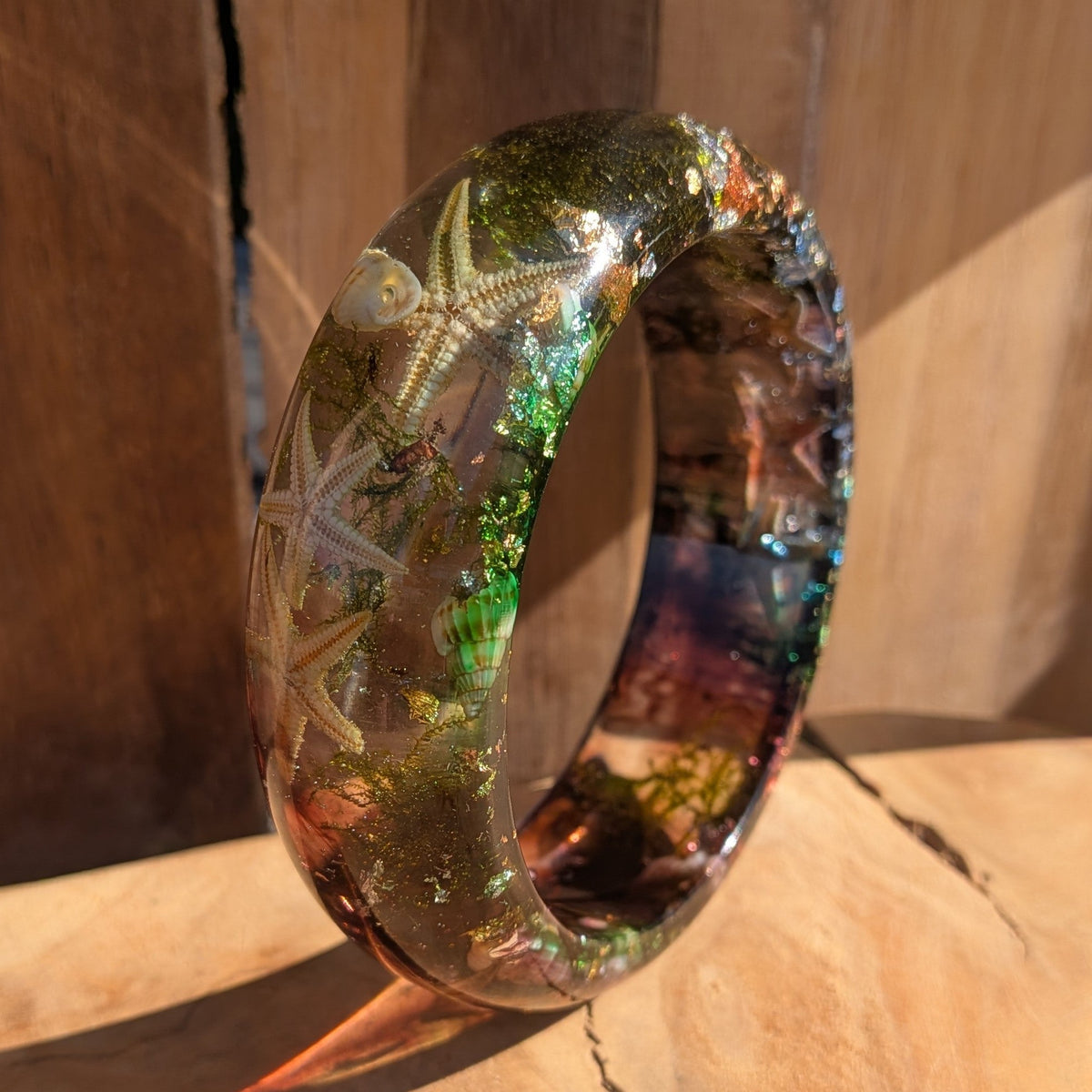 Handmade ocean resin bangle angled view showing real sea moss tendrils and copper gold flakes suspended in resin – EL-Creations