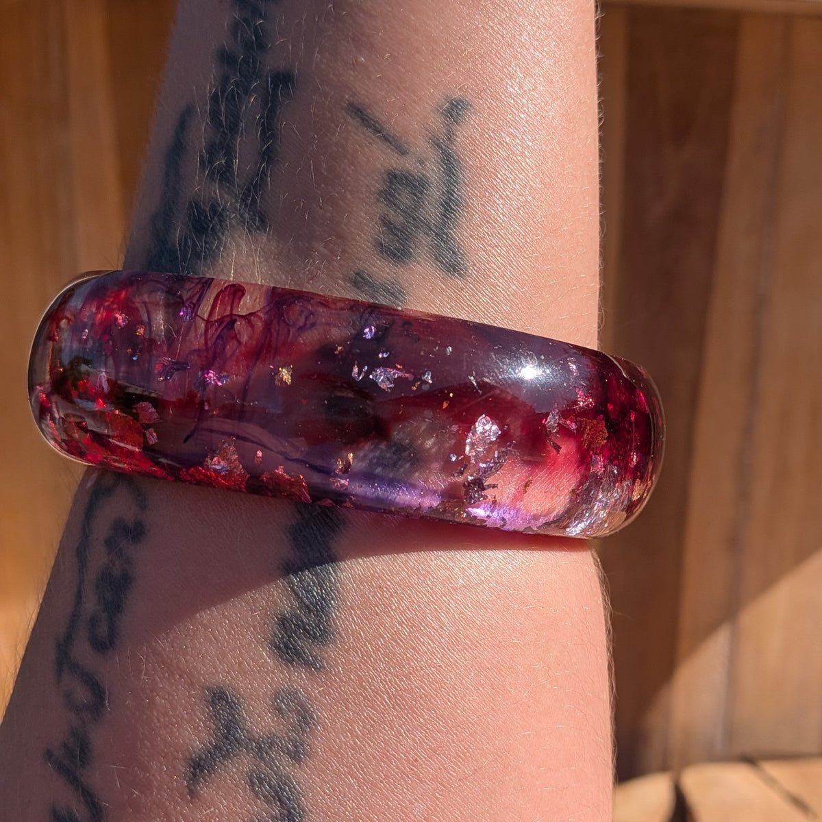 Gothic statement resin bangle deep red violet swirls with gold copper silver flakes worn on wrist outdoor – EL-Creations