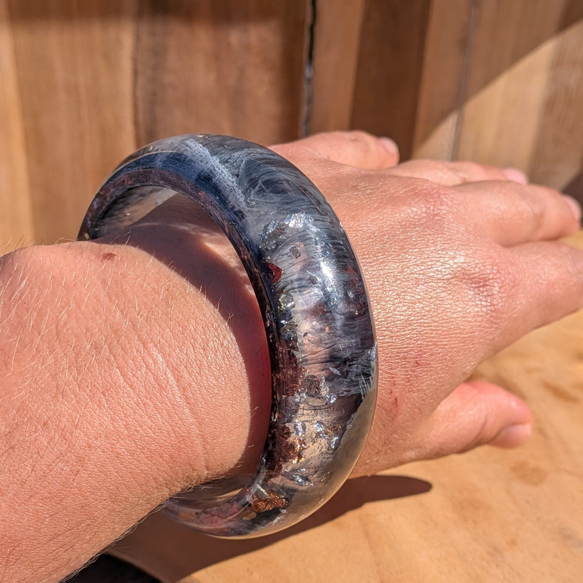 Handmade dome resin bangle worn on wrist close-up showing metallic flake detail and high-gloss surface – EL-Creations