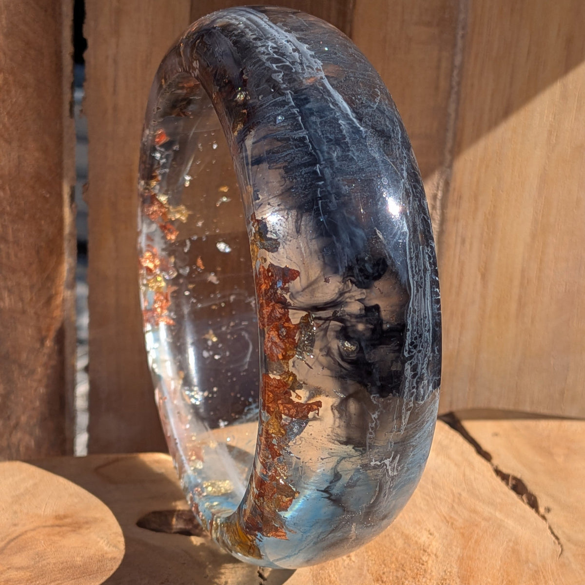 Handmade navy blue resin bangle inner view showing 66mm diameter and clear resin base on wood – EL-Creations
