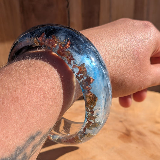 Blue resin bangle worn on wrist close-up showing 23mm width and high-gloss polished surface – EL-Creations