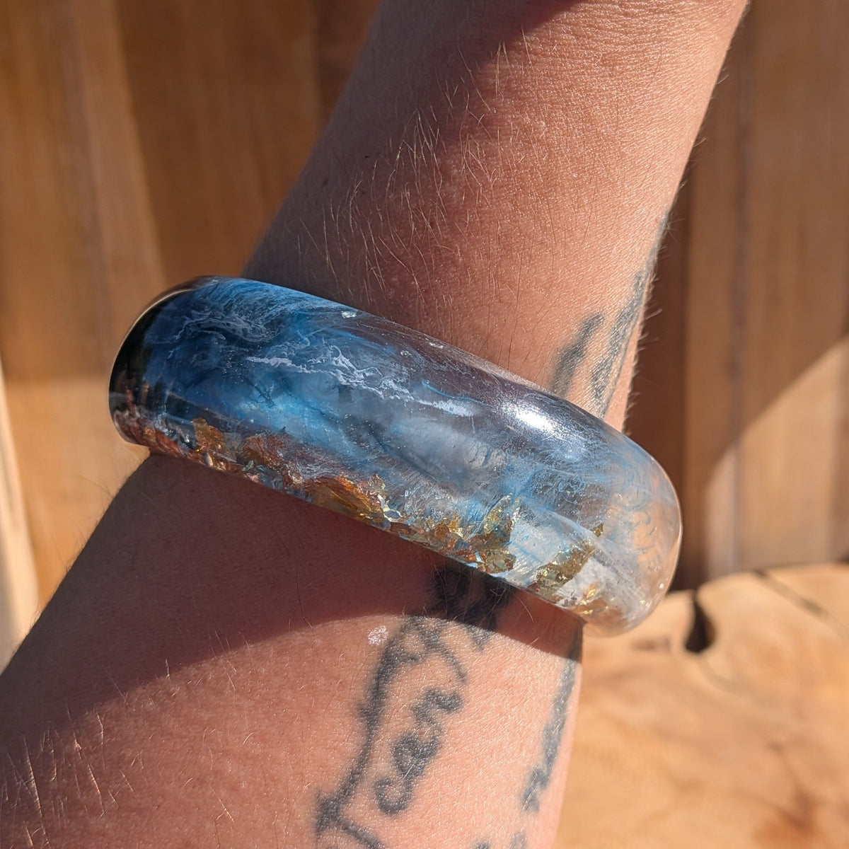 Blue resin statement bangle angled view showing copper and gold flakes suspended in clear resin – EL-Creations