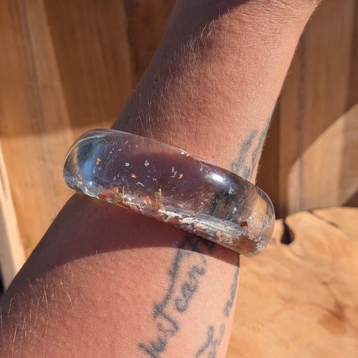 Wide blue resin slip-on bangle with midnight blue paint swirls and copper flakes worn on wrist side view – EL-Creations