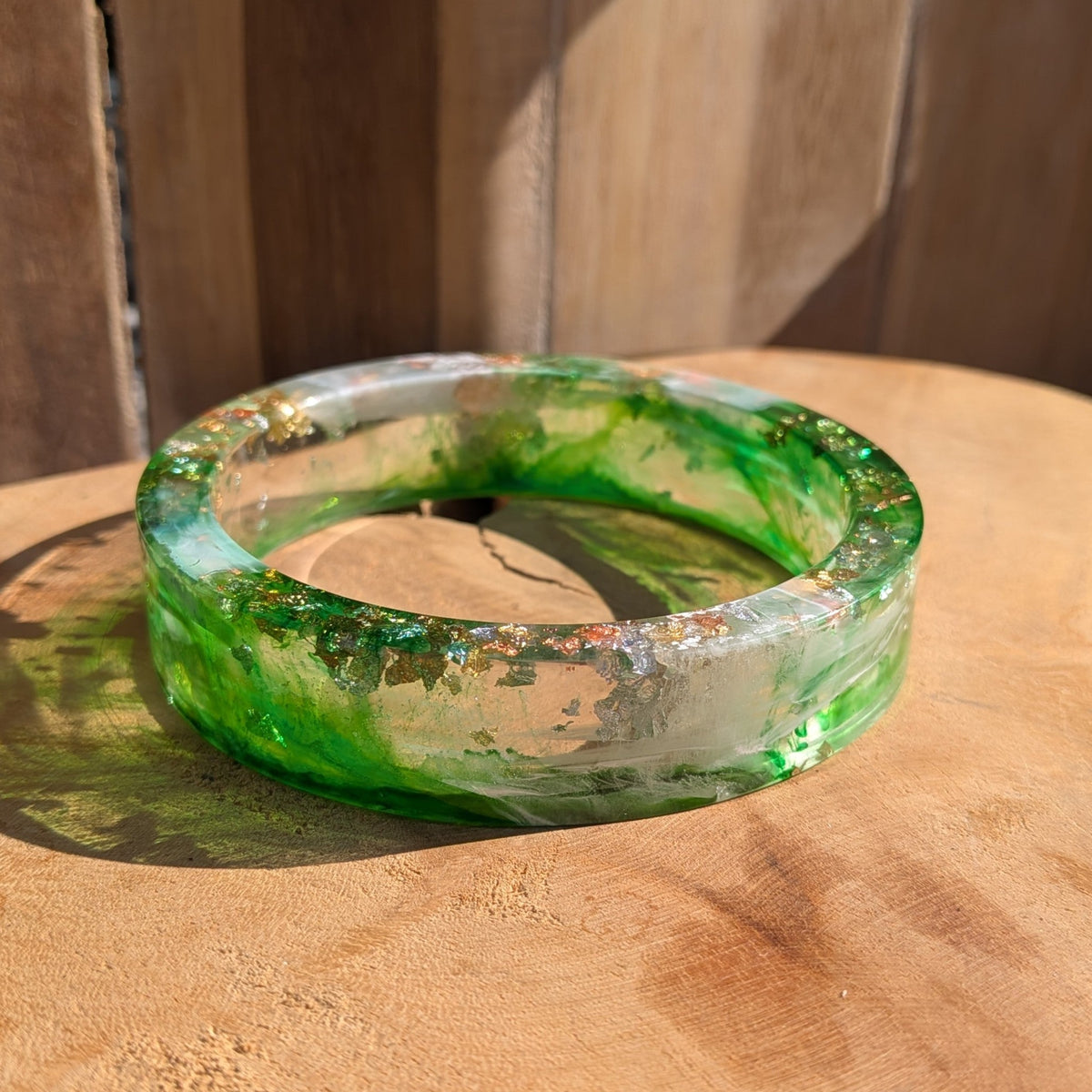 Handmade emerald green resin bangle with silver copper and gold flakes flat lay on wooden surface – EL-Creations