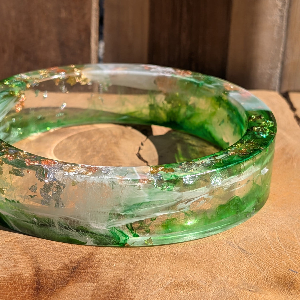 Handmade green resin bangle side view showing 16mm width and high-gloss polished surface on wood – EL-Creations
