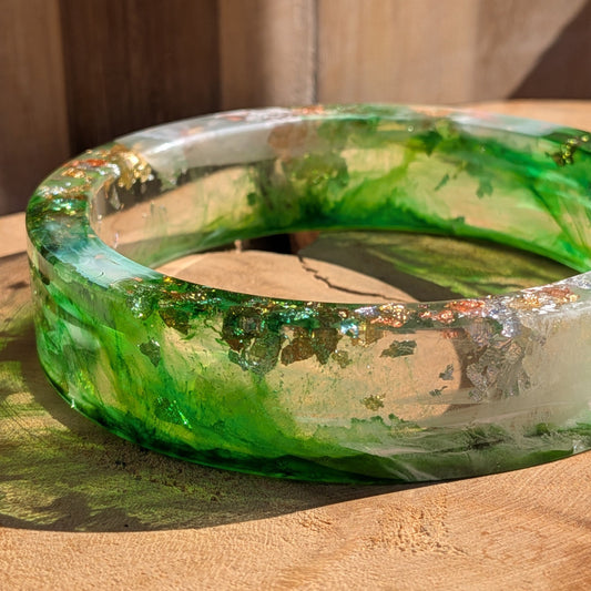 Emerald green resin bangle top view showing inner diameter 69mm and gold copper silver flakes on wood – EL-Creations
