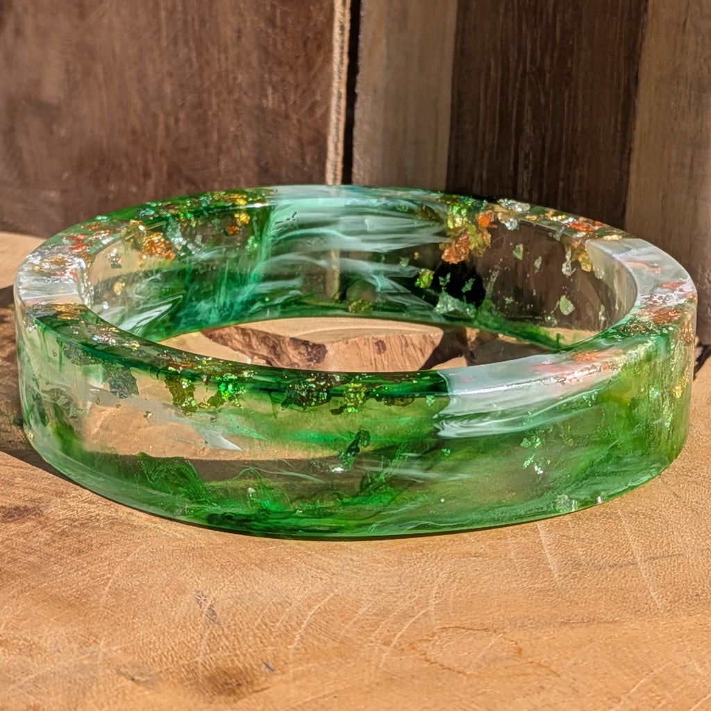 Statement resin bangle emerald green with silver and copper flakes flat lay on driftwood – EL-Creations