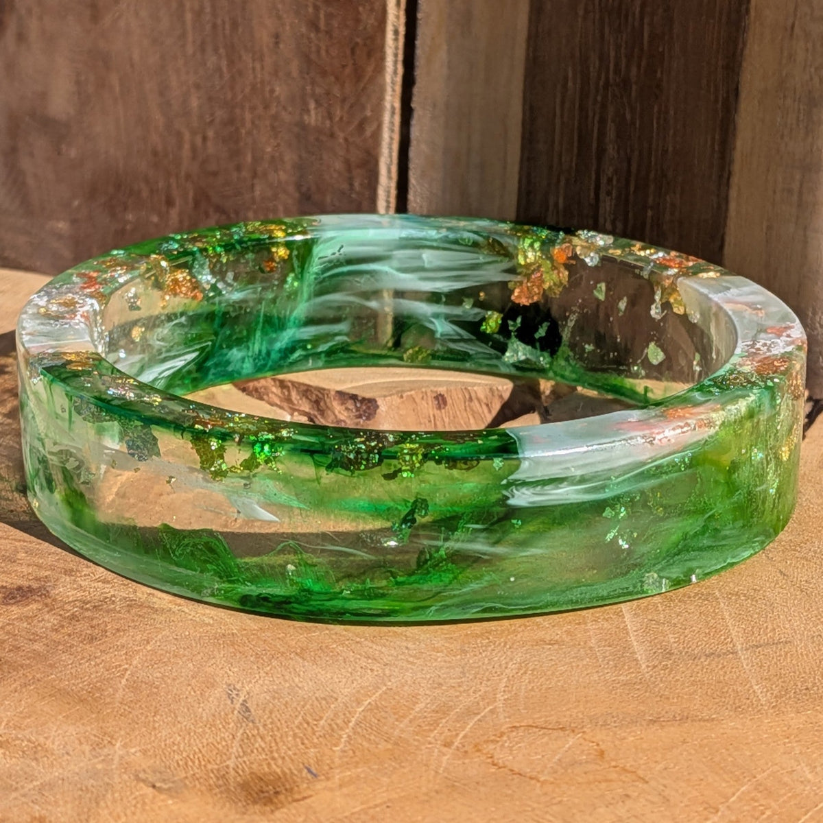 Statement resin bangle emerald green with silver and copper flakes flat lay on driftwood – EL-Creations