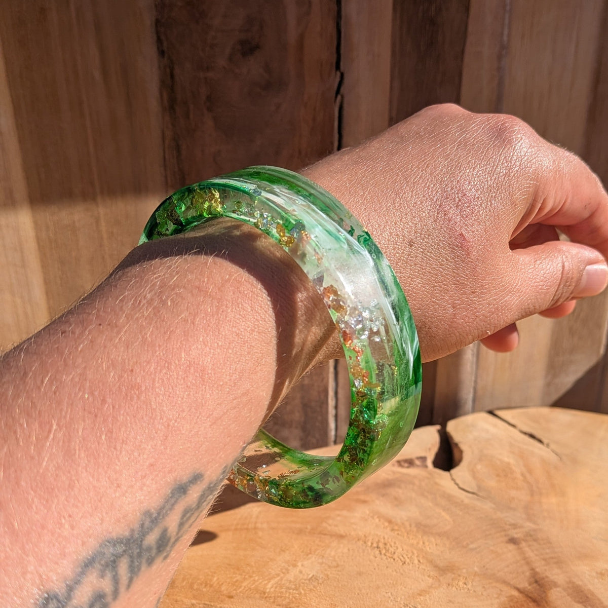 Handmade green resin bracelet with swirling pigment and metallic flakes worn on wrist outdoor – EL-Creations