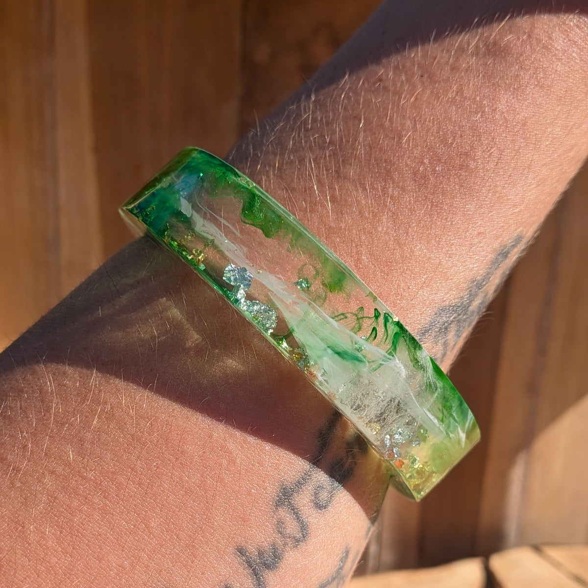 Emerald green resin bangle with gold copper silver flakes close-up showing unique swirl pattern – EL-Creations