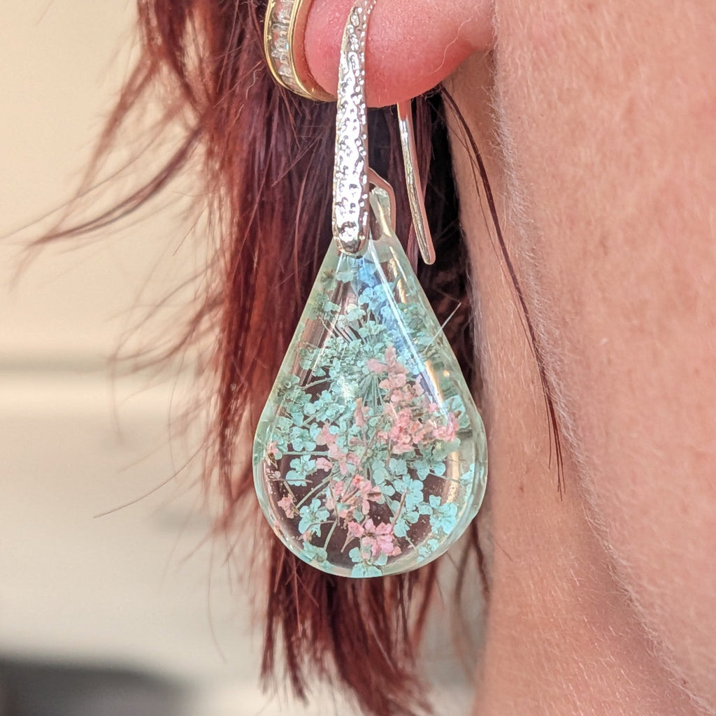 Queen Anne's Lace resin teardrop earrings pressed flowers mint green blush pink held in hand close-up – EL-Creations