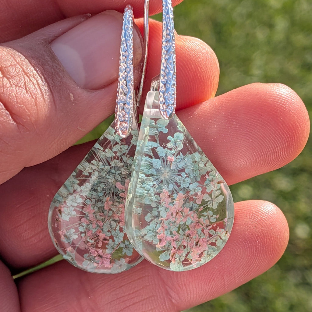 Queen Anne's Lace resin teardrop earrings pair on stone in sunlight side view – EL-Creations