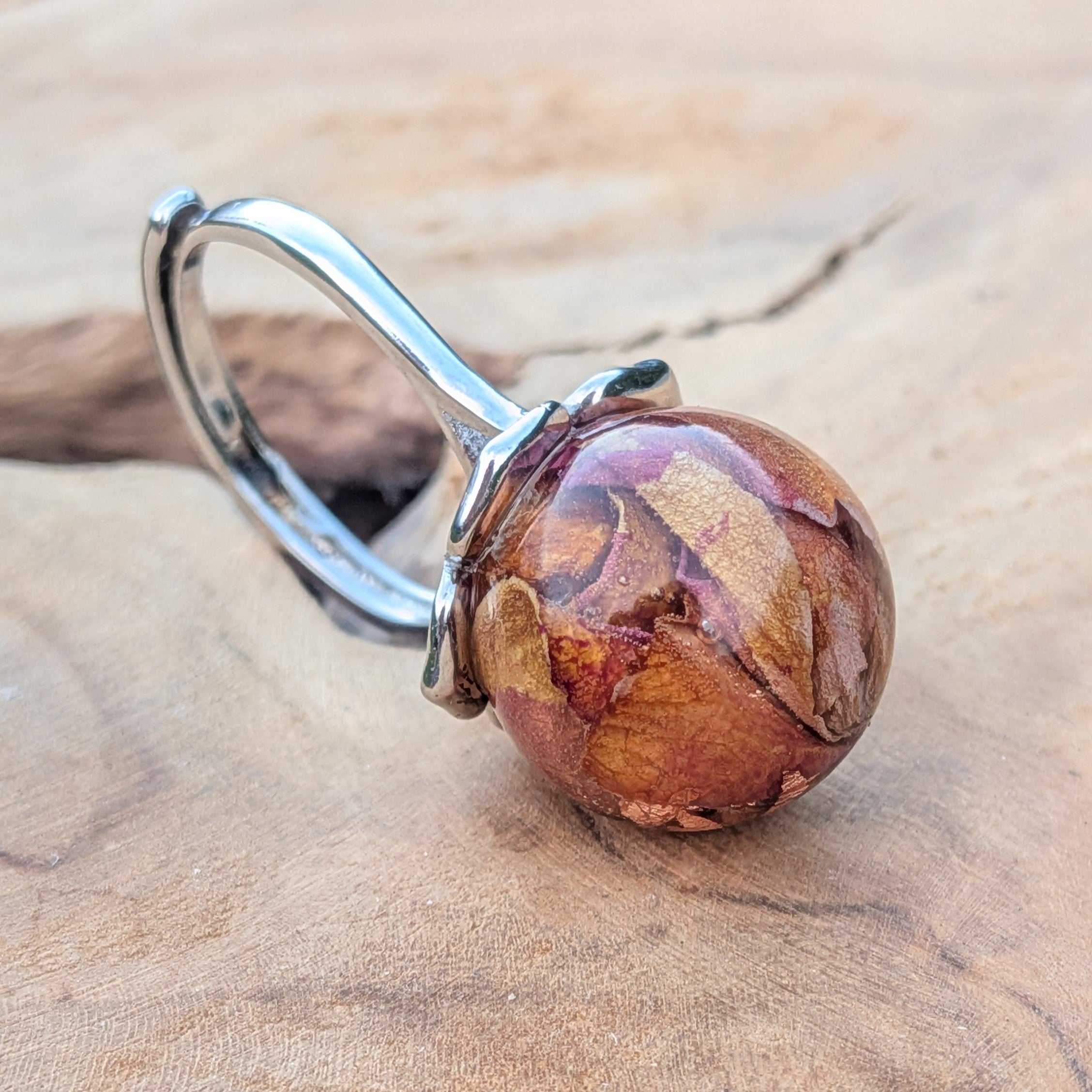Globe resin ring with dried rose petals and copper shimmer – top view on finger – EL-Creations