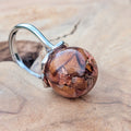 Clear resin ball ring with real rose petals and copper flakes – close-up on finger – EL-Creations