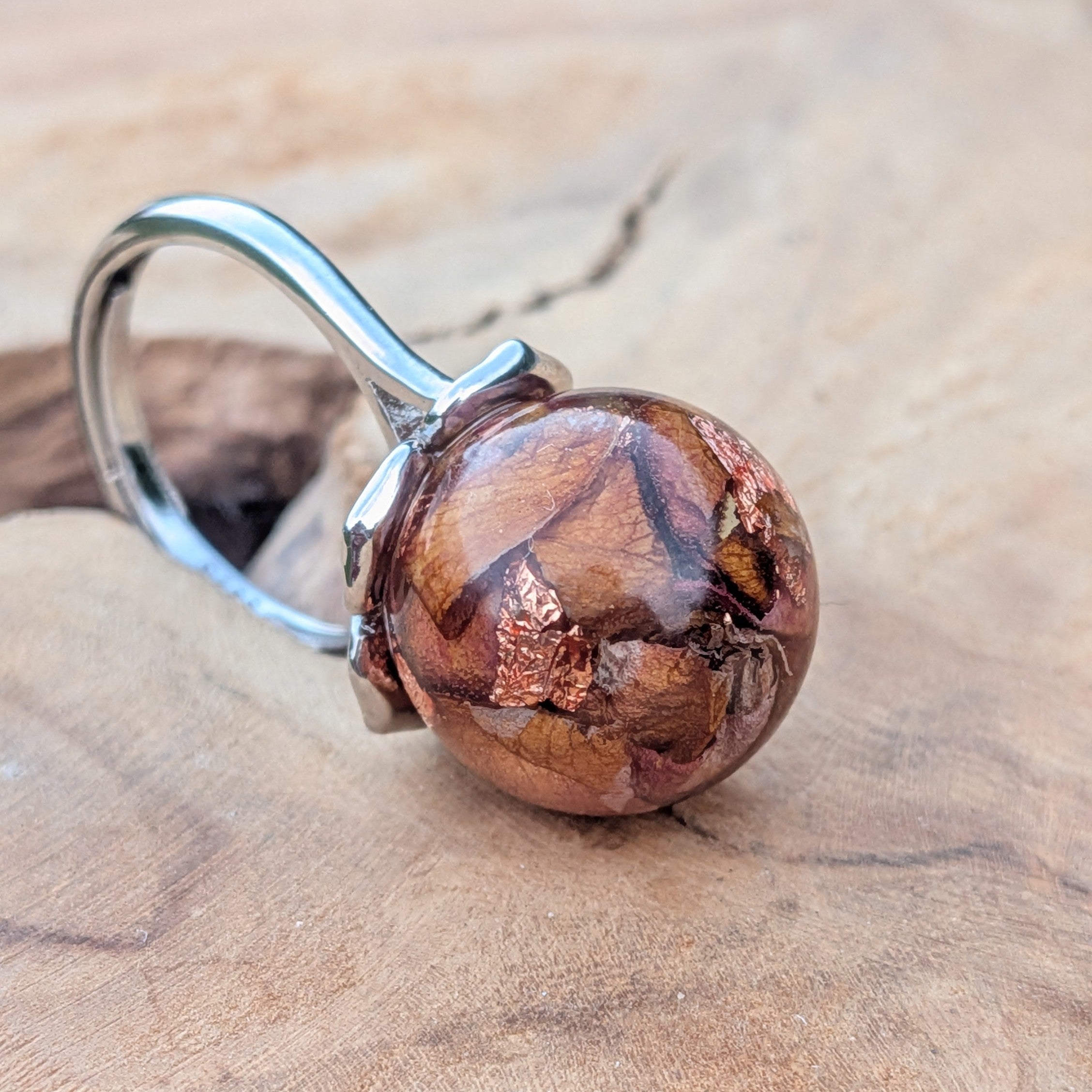Clear resin ball ring with real rose petals and copper flakes – close-up on finger – EL-Creations