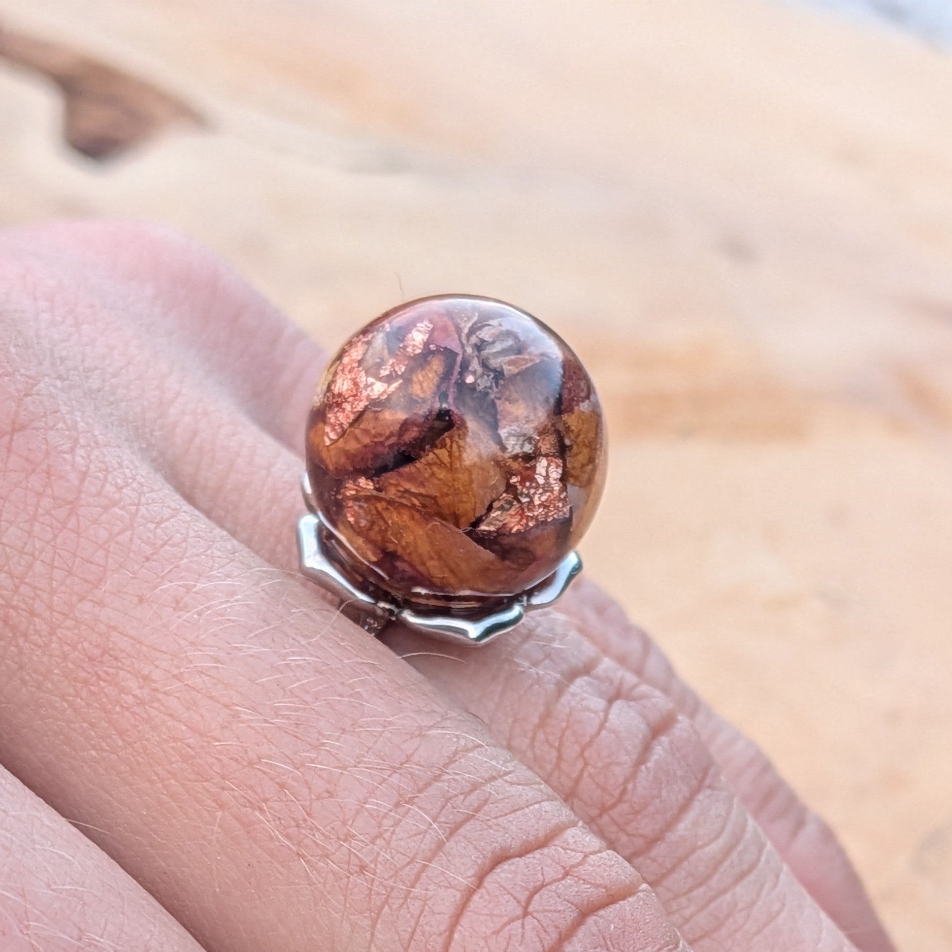 Clear resin globe ring with dried rose petals and copper flakes on silver adjustable band worn on finger – EL-Creations