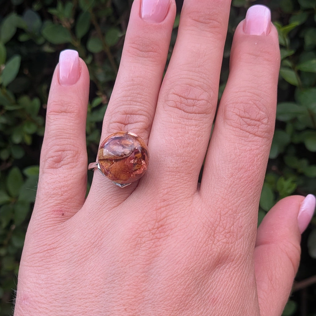 Resin globe ring with dried rose petals and copper shimmer – lying on wood – EL-Creations