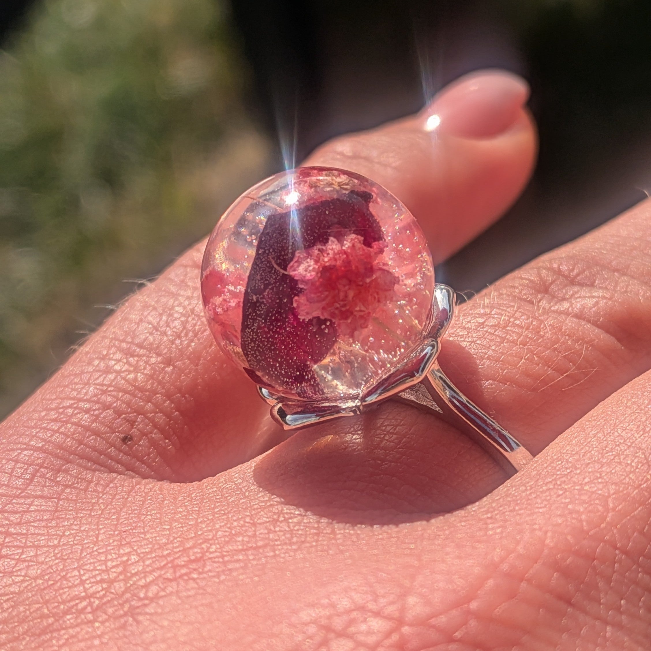 Clear resin ball ring with baby's breath and rose petals – close-up on wood – EL-Creations