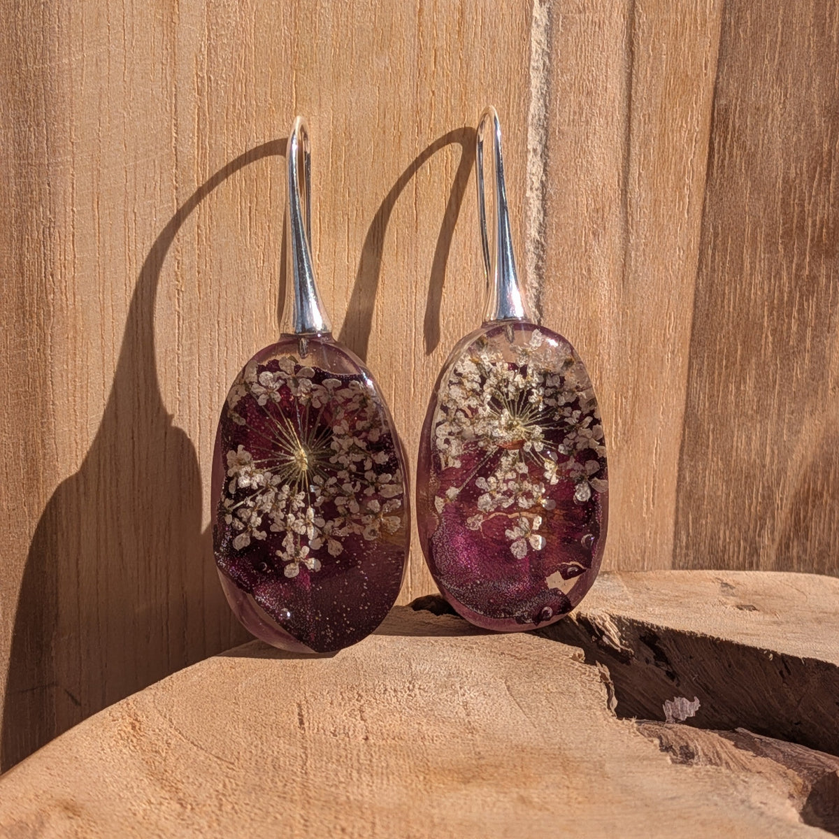 Pair of oval drop earrings with botanical resin pendant in sunlight – EL-Creations