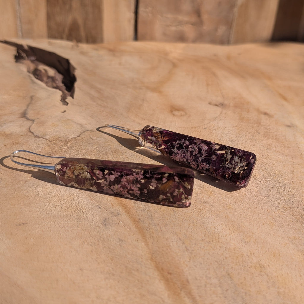 Handmade resin earrings with dried rose petals and Queen Anne's Lace – front view on wood – EL-Creations