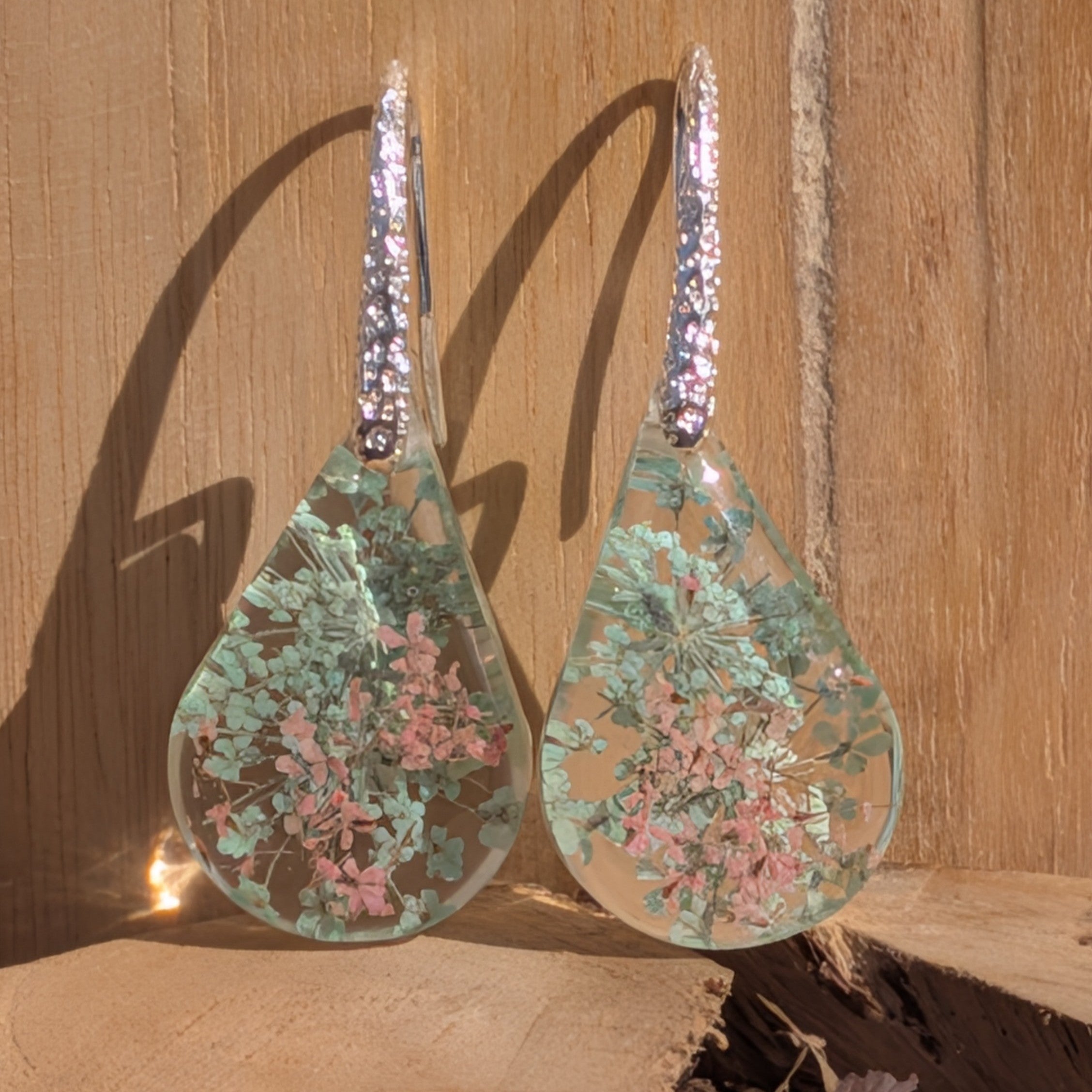 Queen Anne's Lace resin earrings silver crystal lever-back hooks front view on stone surface – EL-Creations