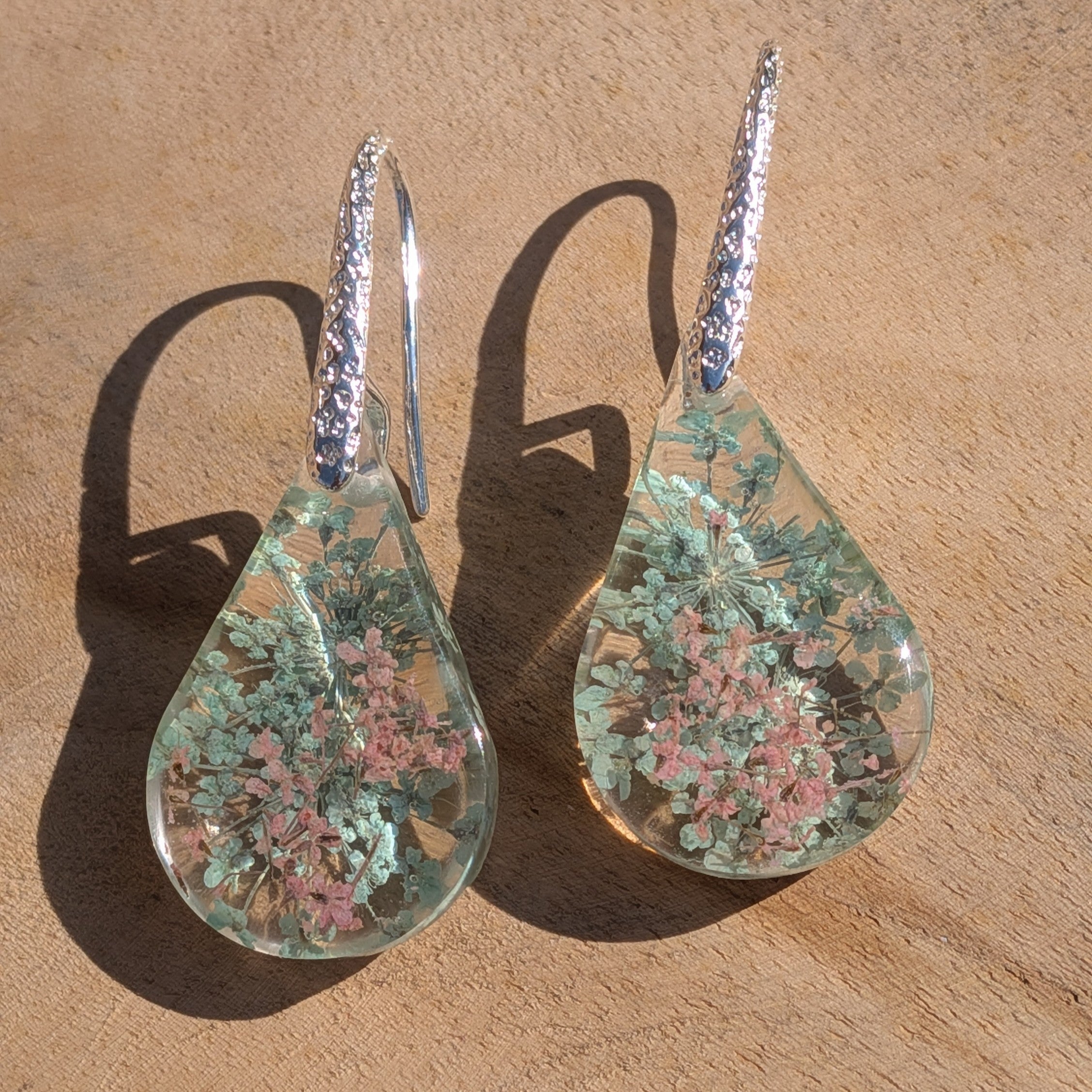 Queen Anne's Lace resin earrings close-up on stone showing pressed flower arrangement – EL-Creations