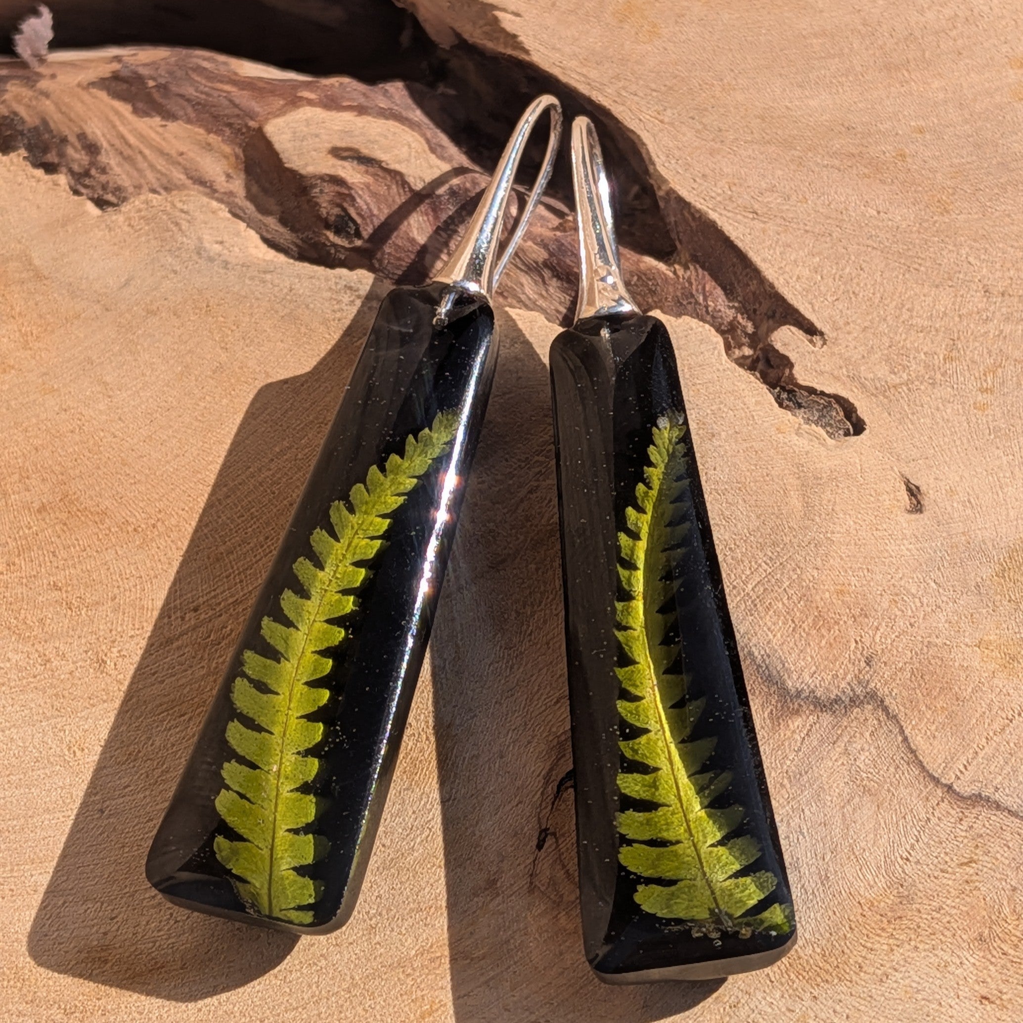 Black resin fern earrings – side view showing depth and glitter shimmer – EL-Creations
