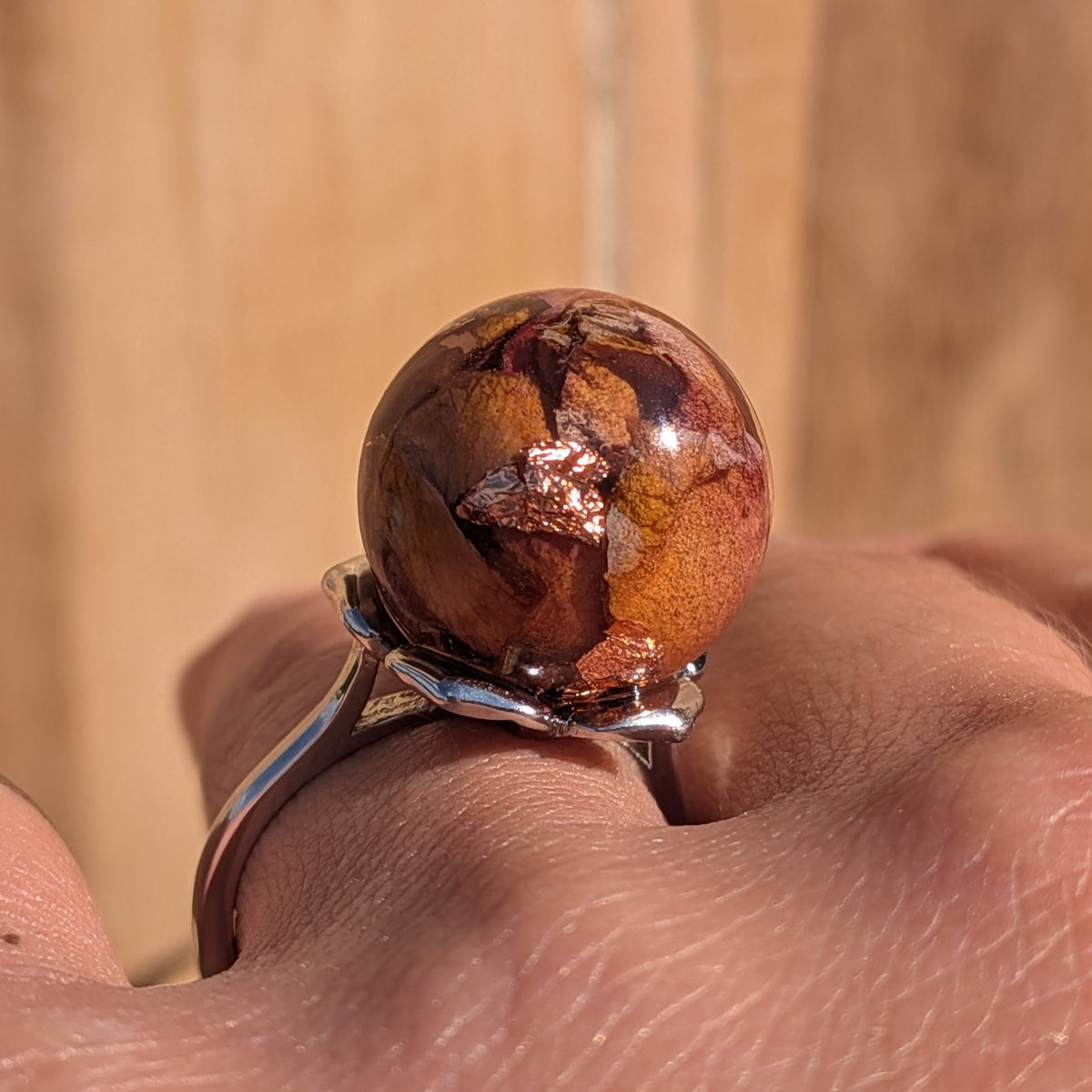 Rose petals and copper flakes resin sphere ring on finger, silver adjustable band, side view – EL-Creations