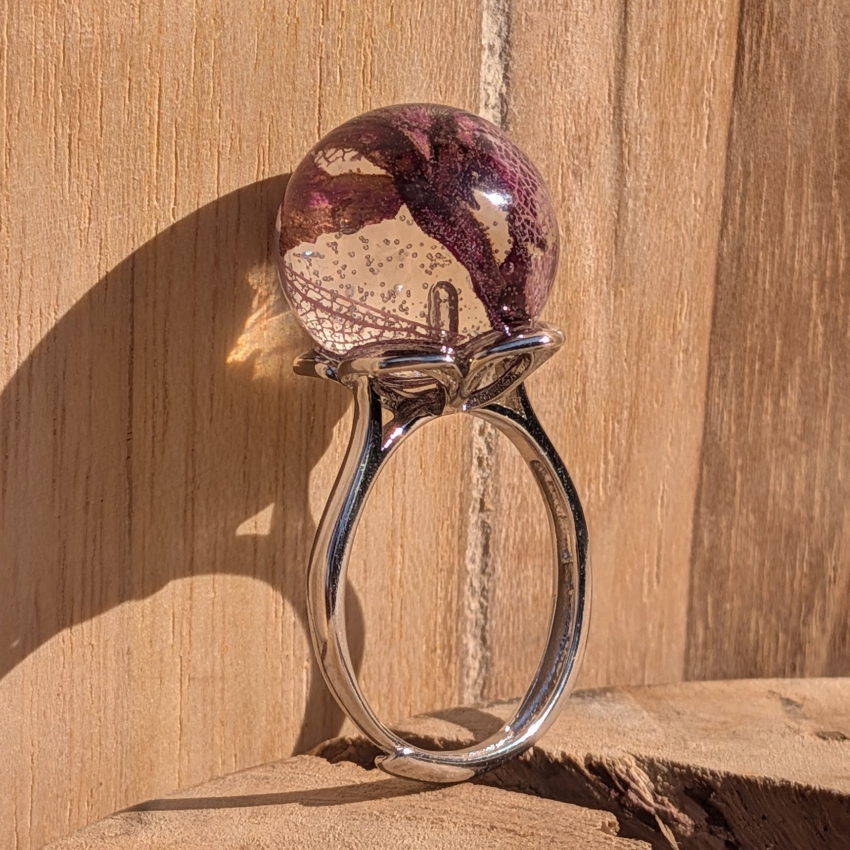 Resin sphere ring with rose petals and skeleton leaf – deep burgundy purple tones on wood – EL-Creations