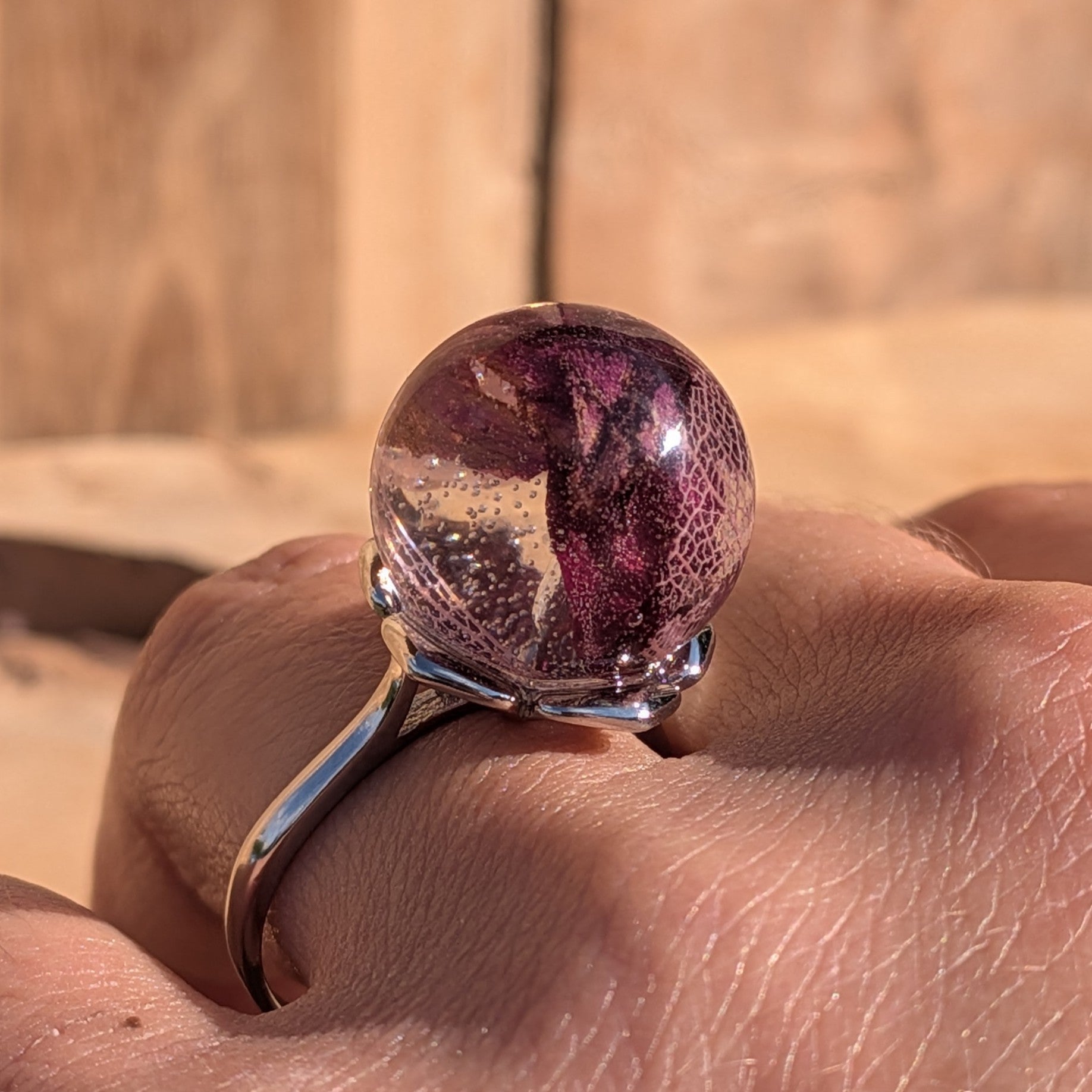 Rose petals and skeleton leaf resin ring – silver adjustable band – close-up on hand – EL-Creations