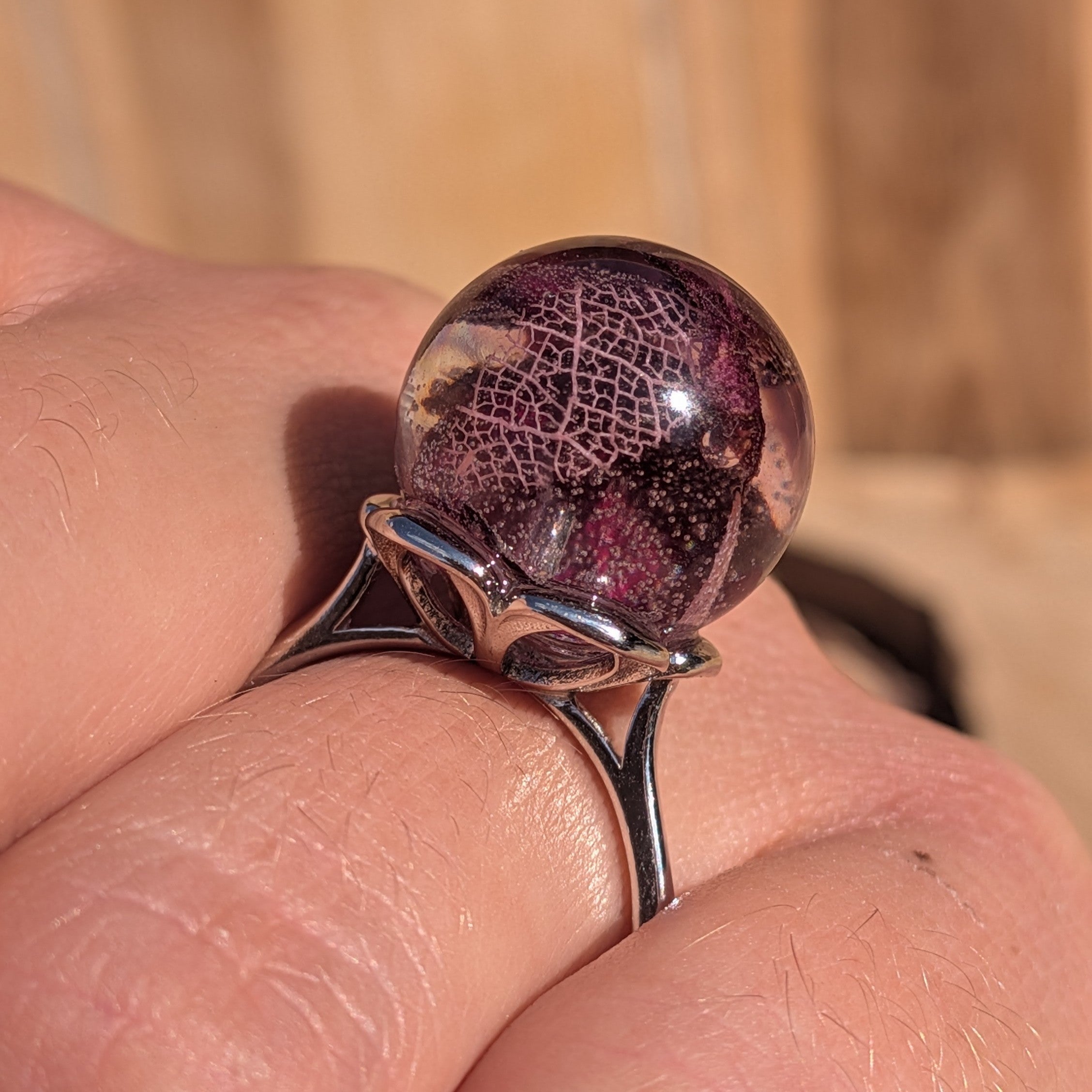 Clear resin globe ring with dried rose petals and skeleton leaf – worn on woman's hand – EL-Creations