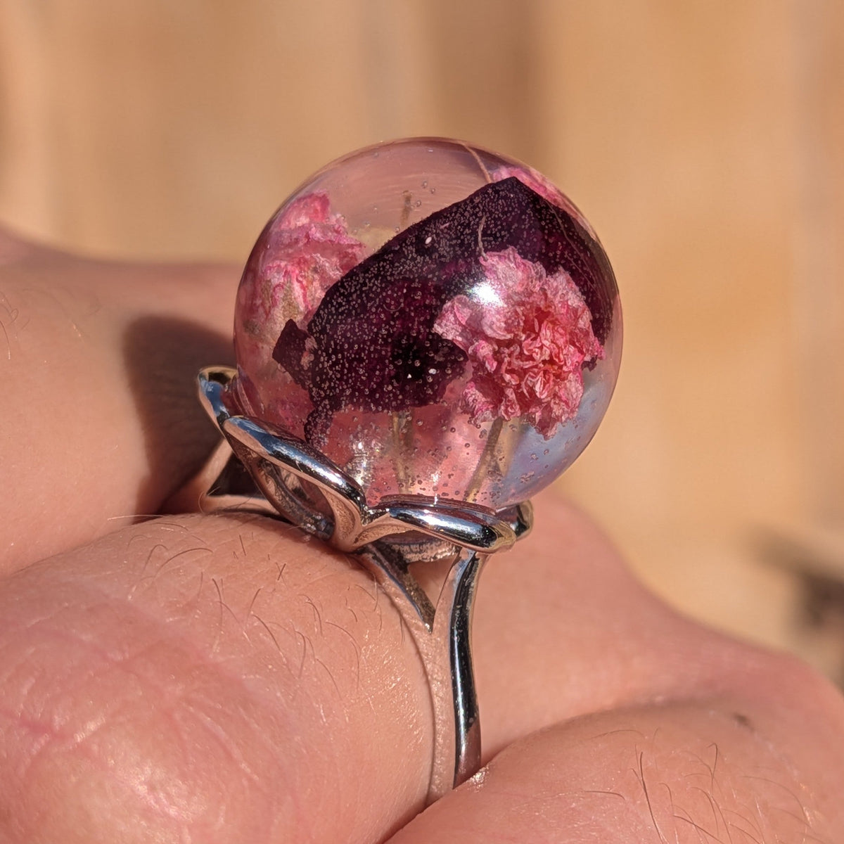 Macro close-up of 15mm resin ball ring with baby's breath and rose petals inclusions – EL-Creations