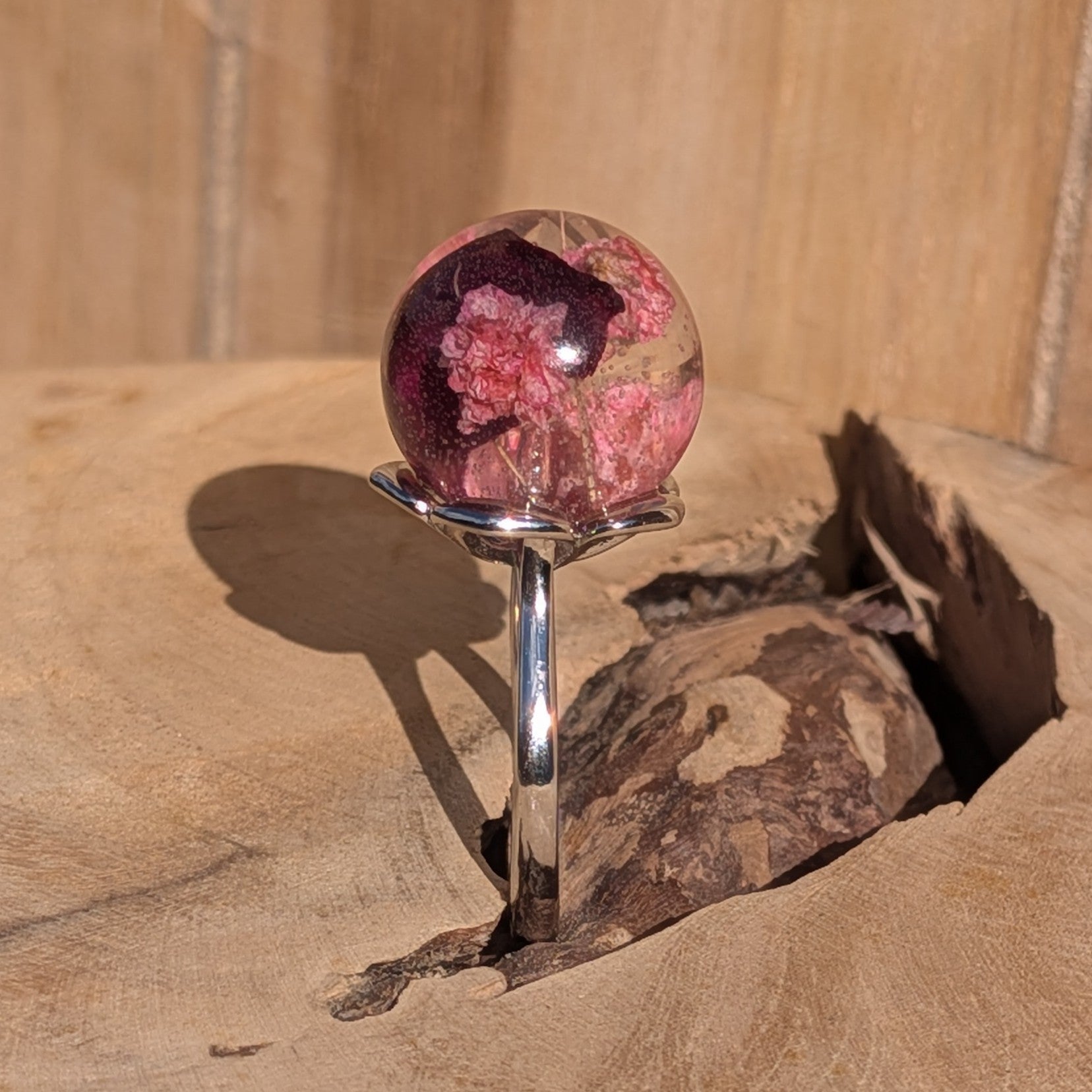 Globe resin ring with baby's breath and rose petals – side view on finger – EL-Creations