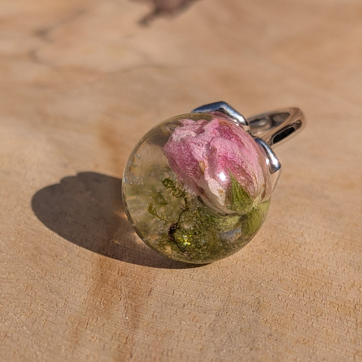Clear resin globe ring with real dried mini rose and green moss on wooden background – EL-Creations