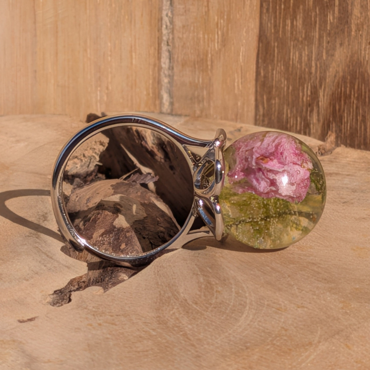Side view of adjustable botanical resin ring with pink rose and moss in clear sphere – EL-Creations