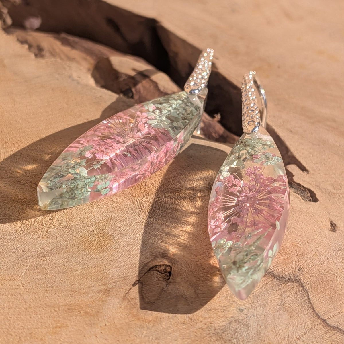 Close-up of pink Queen Anne's lace and moss preserved in clear resin drop – EL-Creations