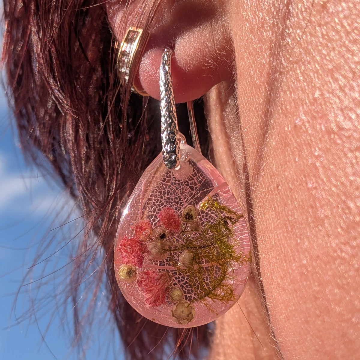 Close-up of skeleton leaf and baby’s breath preserved in pink resin drop – EL-Creations