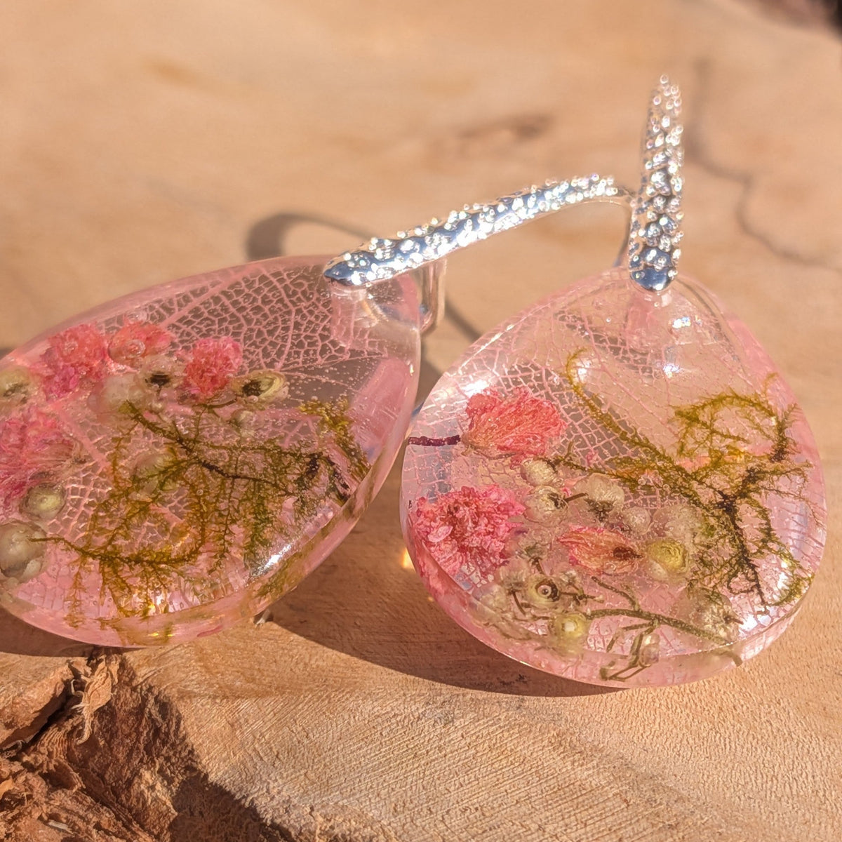 Pink resin teardrop earrings with skeleton leaf botanical pattern in sunlight – EL-Creations