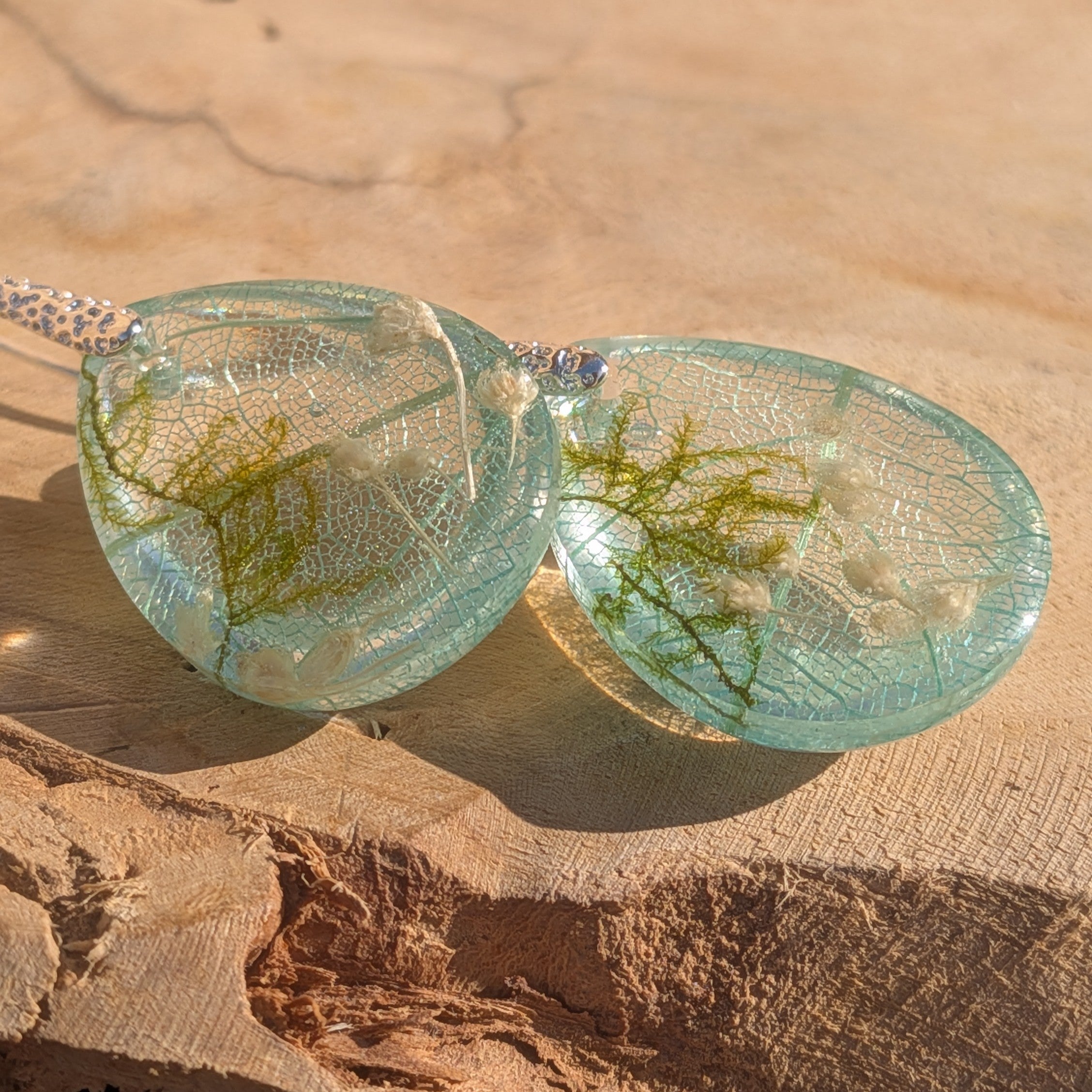 Skeleton leaf resin earrings silver ornate hooks on wood diagonal view moss wildflowers – EL-Creations