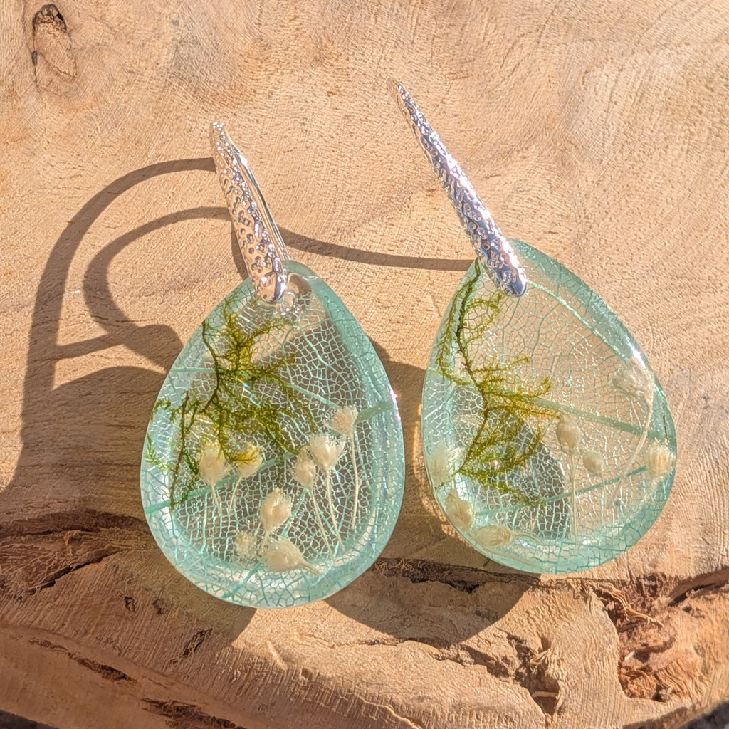 Skeleton leaf resin earrings side profile on wood showing dome depth and botanical inclusions – EL-Creations