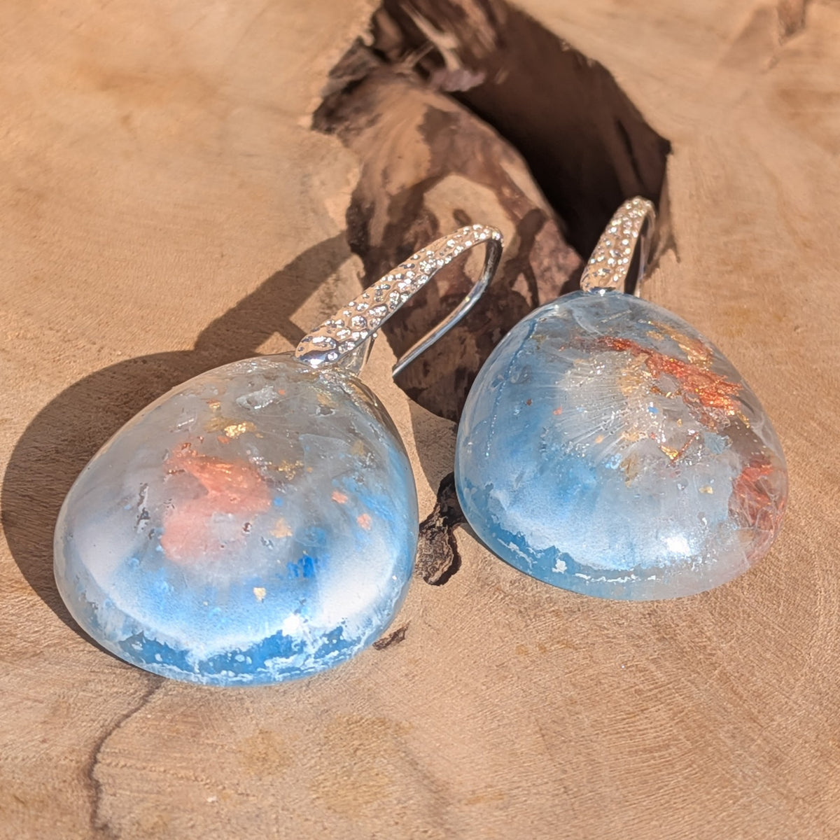Detailed view of copper flakes inside blue and white resin drop earrings, EL-Creations