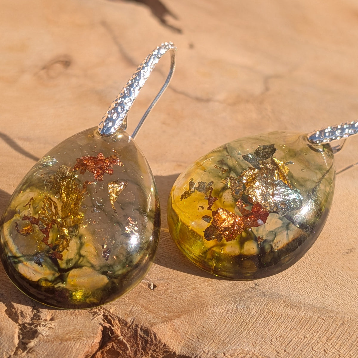 Detailed view of metallic flakes in translucent amber and olive earrings, EL-Creations