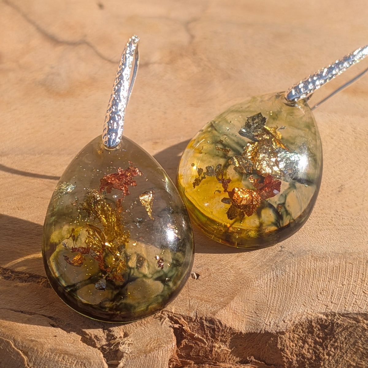 Diagonal view of olive green teardrop earrings with silver hooks, EL-Creations