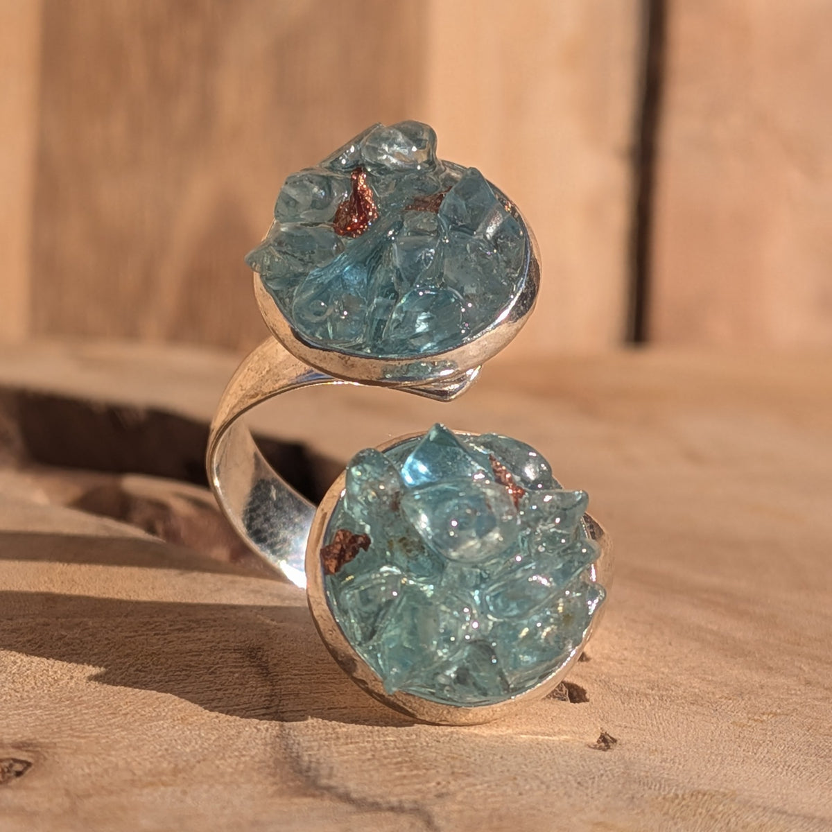 Blue topaz double cluster ring with an adjustable silver-coloured alloy band on wood, EL-Creations