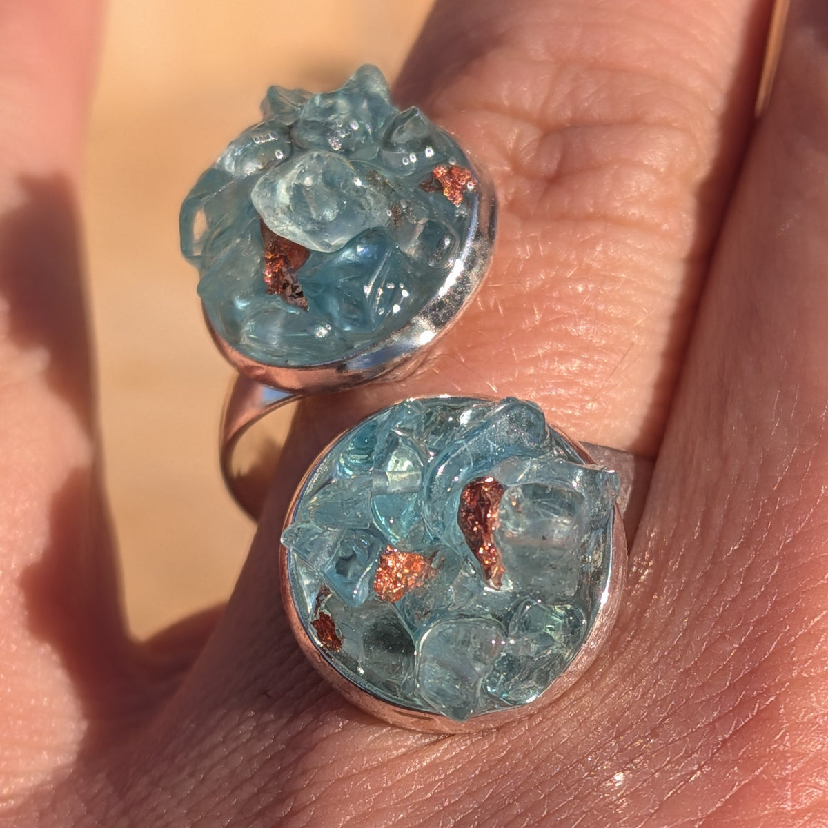 Top view of the blue topaz ring worn on a finger showing both gemstone clusters, EL-Creations