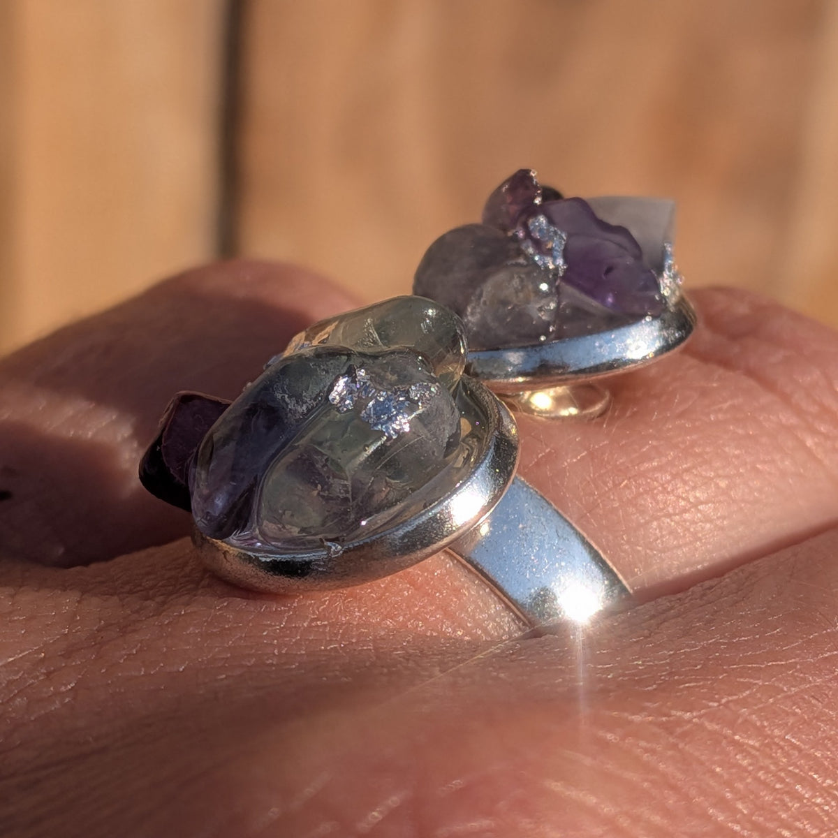 Macro side view of the fluorite ring worn on a finger showing raised stone details, EL-Creations