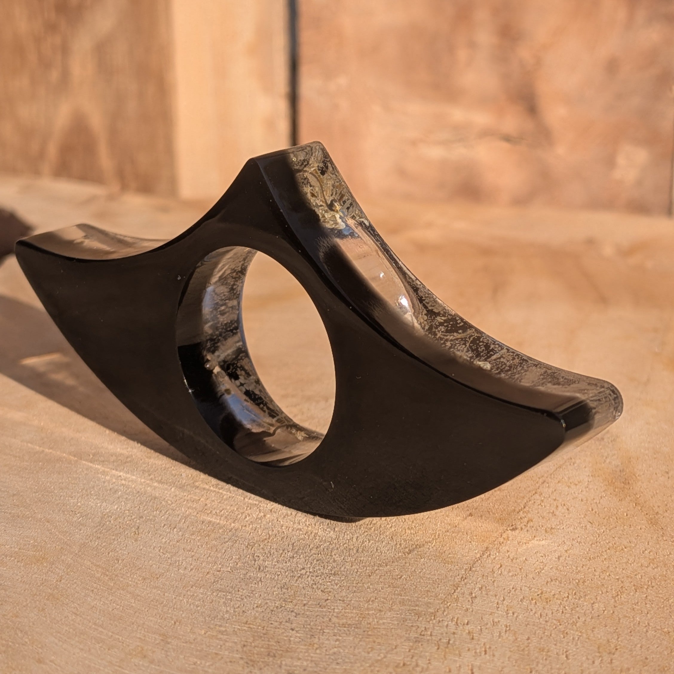 Black resin book ring with Queen Anne's Lace – wing shaped silhouette on wooden surface – EL-Creations