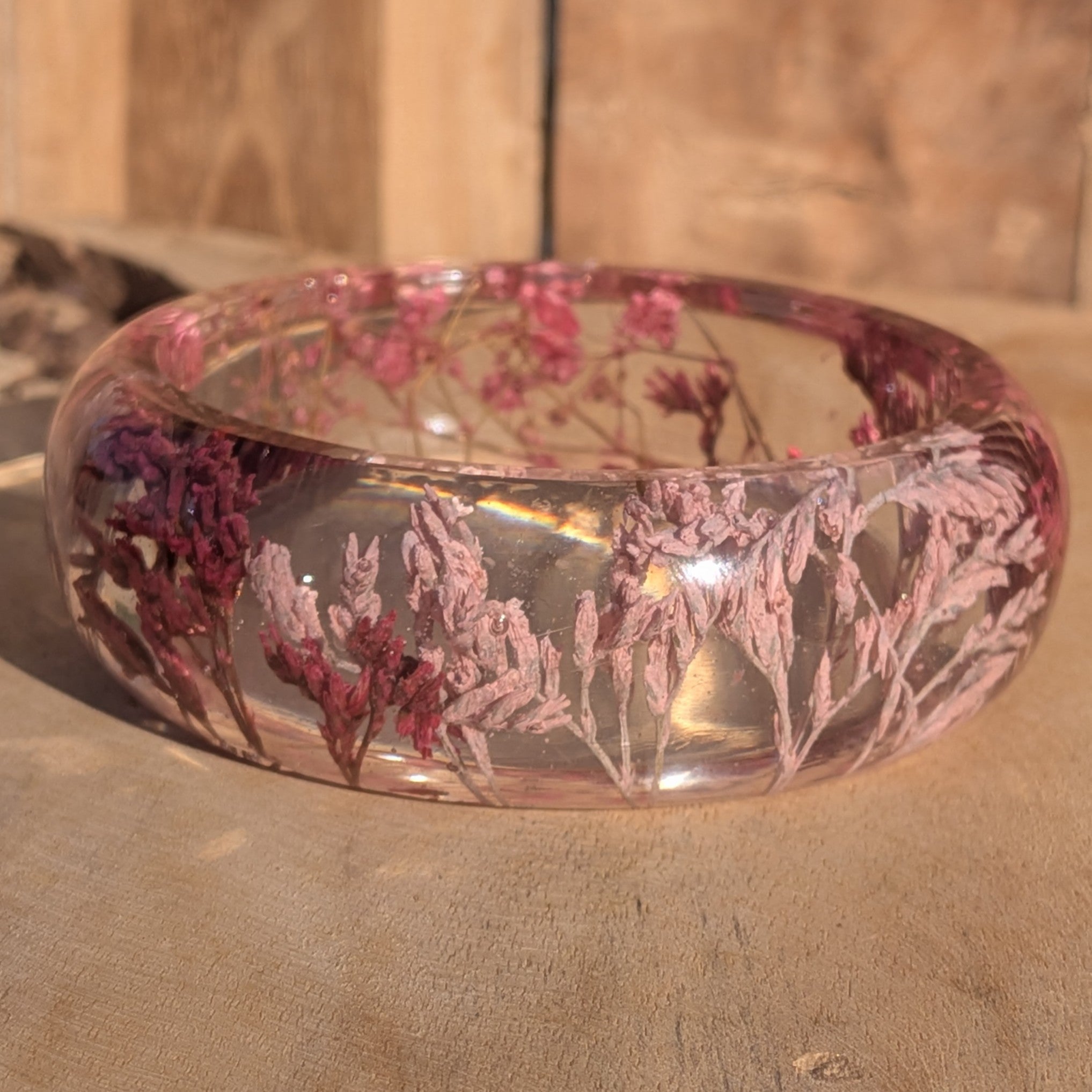 Resin bangle with dried pink wild flowers – side view showing domed profile and glossy finish – EL-Creations